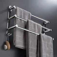 a towel rack with two towels hanging from it's sides and a wooden roller attached to the wall