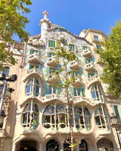 an ornate building with many windows and balconies on the front, surrounded by trees