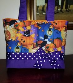 a purple and white polka dot purse on a table