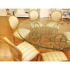 a glass table with chairs around it on top of a hard wood floored floor