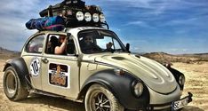 an old vw bug with luggage on top in the desert