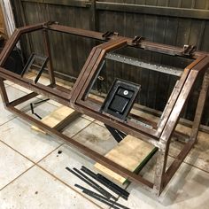 three wooden frames sitting on top of a tile floor next to some wood planks