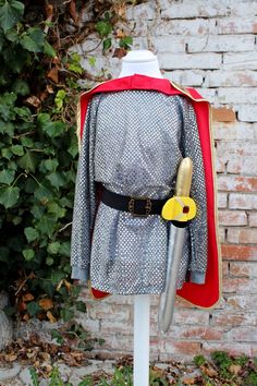 Kids knight costume with tunic, belt and cape ( please write me in the notes if you want the cape in red or in burgundy ). I've a version without a cape that you can find here: https://www.etsy.com/it/SartoriaTataDrama/listing/1059729373/  You can choose the option with the foam sword or without.  This costume is beautiful and super stylish, easy to wear and very comfortable.  -The tunic is made in silver sequined polyester. The crew neck and cuffs are made in cotton jersey so it doesn't itch :) Toddler Knight Costume, Kids Knight Costume, Knight Costume For Kids, Girls Butterfly Costume, Costume Chevalier, Fairy Costume For Girl, Knight Dress, Knight Party, King Costume