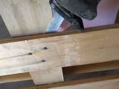 a person working on some wood with a pair of pliers next to it and a piece of wood that has been cut in half