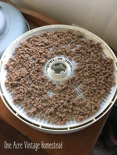 a large pan filled with meat on top of a wooden table