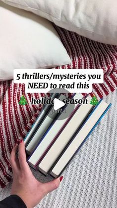 a person holding a stack of books with the text 5 thrifts / mysteries you need to read this holiday season