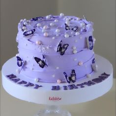 there is a purple cake with butterflies on it