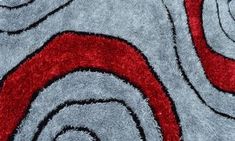 a red and gray area rug with swirls on the bottom in an abstract pattern