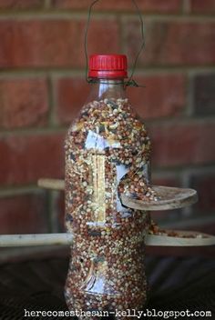 a bottle filled with bird seed sitting on top of a table