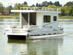 a white houseboat floating on top of a body of water