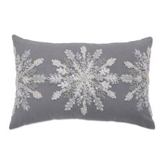 a grey and white pillow with an embroidered snowflake design on the front,