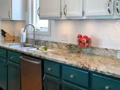 a kitchen with green cabinets and marble counter tops, stainless steel dishwasher and sink