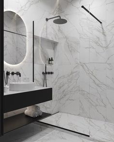 a bathroom with marble walls and flooring in black, white and grey colors is shown