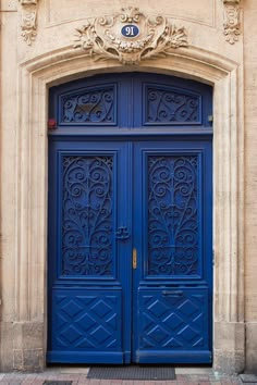 an ornately decorated blue door on the side of a building