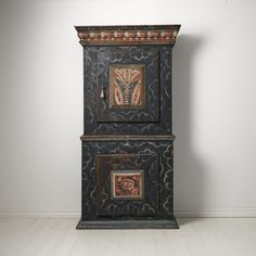 an old wooden cabinet with two paintings on the front and back doors, in a white room