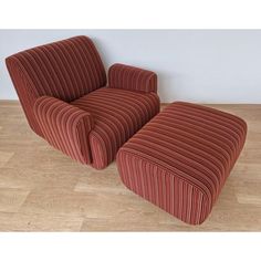 a red chair and ottoman sitting on top of a hard wood floor