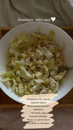 a white bowl filled with lettuce next to a wooden tray