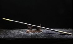 two fishing rods sitting on top of a wooden table next to a black background with the caption's name