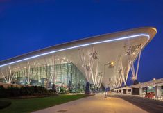 a large building with many lights on it's side and grass in the foreground