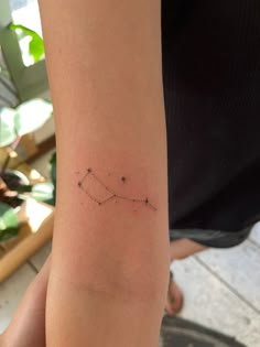 a woman's arm with a small star tattoo on it