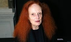 an old woman with red hair is looking at the camera while wearing a black shirt