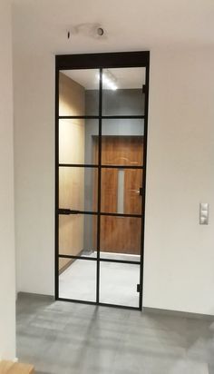 an empty room with a wooden door and glass partition in the wall to let light into it