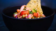 a black bowl filled with salsa and tortilla chips