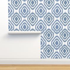 a blue and white wallpaper with an abstract design on the wall next to a wooden floor