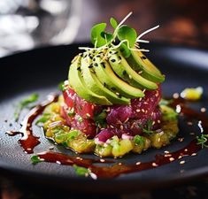 a black plate topped with an avocado on top of other food items and garnishes