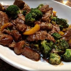 a white plate topped with beef and broccoli