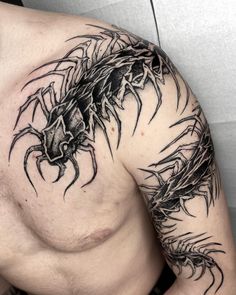 a man's chest with a scorpion tattoo on it, and an insect in the middle