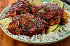 two pieces of meat covered in sauce and garnished with cilantro on top of white rice