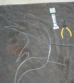 scissors and wires are laid out on top of a t - shirt that has been drawn onto