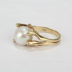 A fine, modernist 14k yellow gold and baroque pearl cocktail ring from the mid-20th century.  Features a large baroque pearl in an organic, pronged setting.  Interior of shank stamped: 14K   Overall Width: ca. 3/4 in. Ring size: 6 1/4  Pearl size:  Ca. 11mm x 13mm    Dimensions reference the ring size and are not specific to the ring itself. Pearl Cocktail Ring, Pearl Size, Baroque Pearls, Cocktail Ring, Cocktail Rings, Rose Gold Ring, Floral Rings, Gold Rings, Gemstone Rings