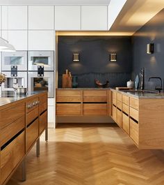 a large kitchen with wooden cabinets and counter tops in an open floor plan, along with hardwood floors