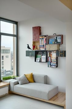 there is a book shelf with many books on it and a bird sitting on top