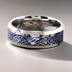 a wedding band with blue and silver inlays is shown on a white surface