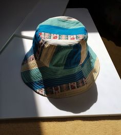 Cotton patchwork bucket hat. These come from dormant stocks of major Maisons and upcycled second-hand clothing. The inside edge of the bucket hat is made of sky blue denim-style cotton. Dark green lining in cotton and polyester voile. Head circumference: 56.5 cm Blue Retro Bucket Hat With Curved Brim, Retro Blue Bucket Hat With Curved Brim, Green Reversible Cotton Bucket Hat, Green Reversible Cotton Hat, Casual Cotton Patchwork Hat, Blue Bohemian Cotton Hat, Vintage Blue Wide Brim Bucket Hat, Vintage Wide Brim Blue Bucket Hat, Reversible Multicolor Cotton Bucket Hat