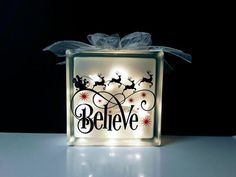 a lighted box that says believe with santa's sleigh and reindeers