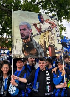 a group of people holding up a large poster with an image of soccer player on it