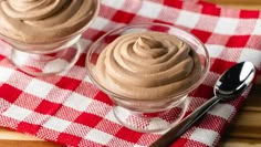 two desserts on a red and white checkered tablecloth with silverware next to them