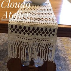 a white bowl sitting on top of a wooden table next to a doily covered table