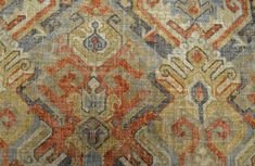 an old rug with many different colors and patterns on it's surface, including red, blue, yellow, orange, and grey