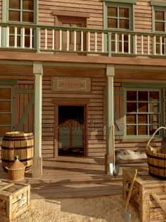 an old wooden building with barrels in front