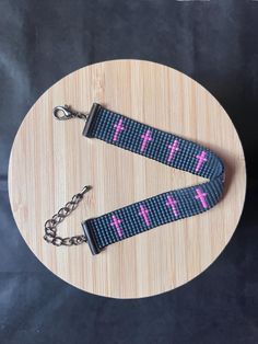 two blue and pink cross keychains sitting on top of a wooden table