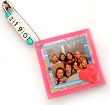 a pink photo frame with a heart hanging from it's side on a lanyard