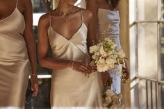 three bridesmaids standing in front of an open window