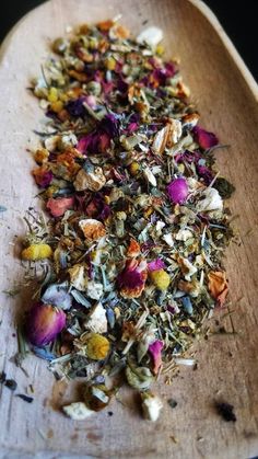 a wooden spoon filled with dried flowers on top of a table