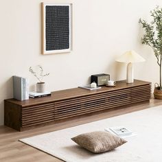 a living room with a white rug and wooden shelves on the wall next to a lamp