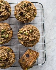 six muffins on a cooling rack with nuts and raisins in them